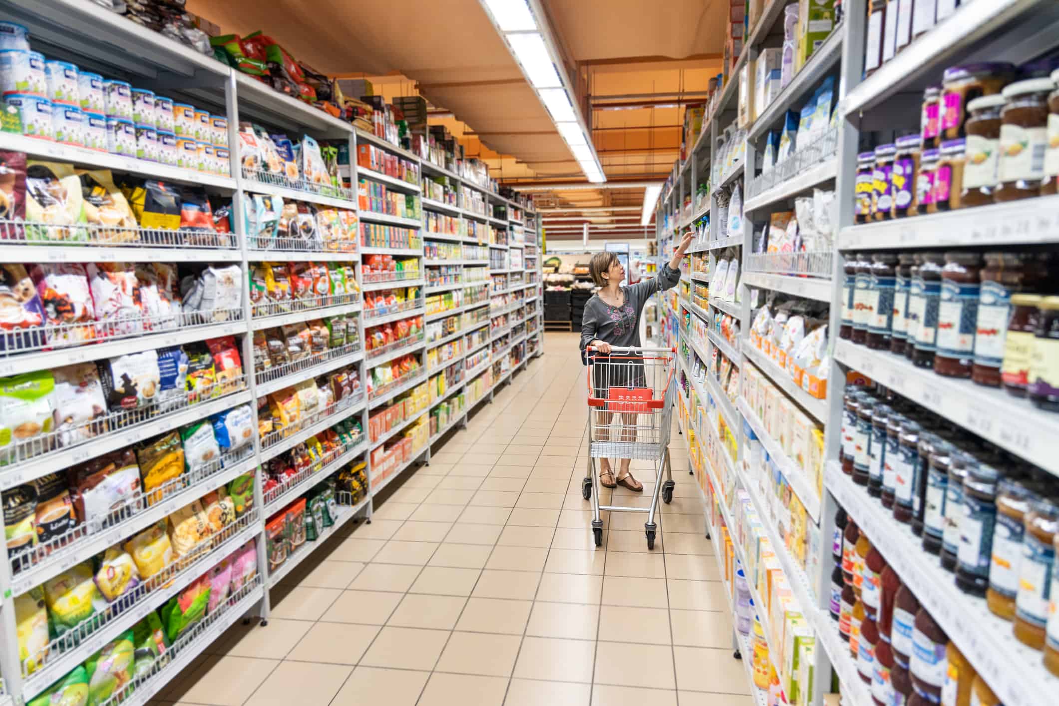 Series of Asian woman shopping groceries in modern supermarket with shopping cart selecting products