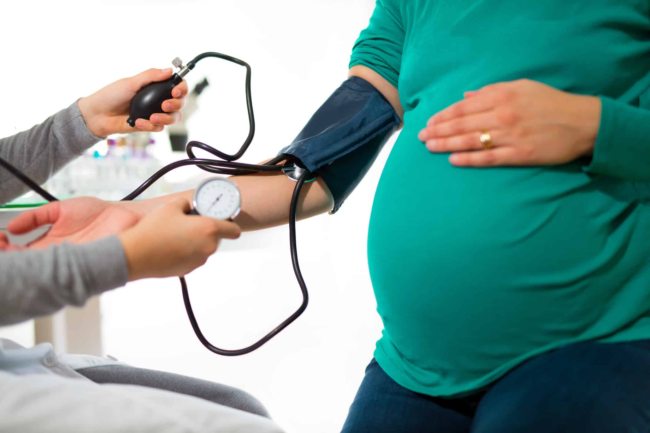 Pregnant woman at doctor's office having pressure measured, close up